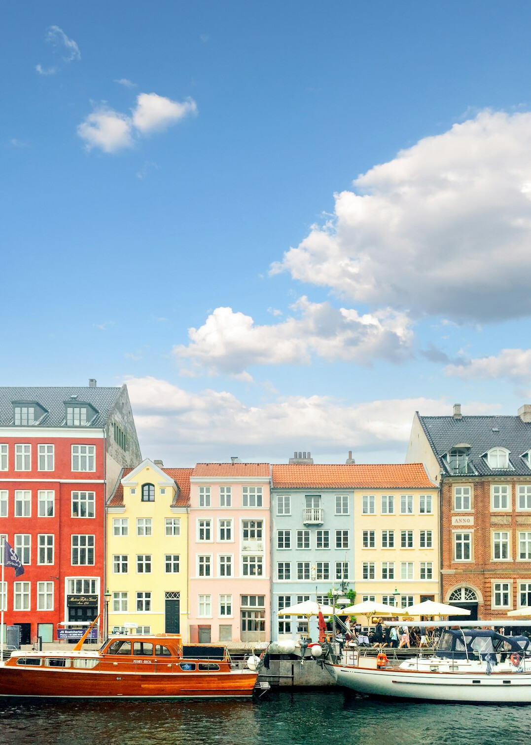 Colorful waterfront houses in Copenhagen with people walking